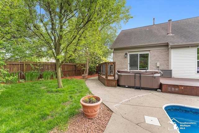 25345 Hunter Ln, Flat Rock, MI 48134 - back of property with a hot tub, a patio area, brick siding, and roof with shingles