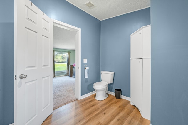3311 5 Mile Rd, Sears, MI 49679 - bathroom featuring wood finished floors, toilet, and a textured ceiling