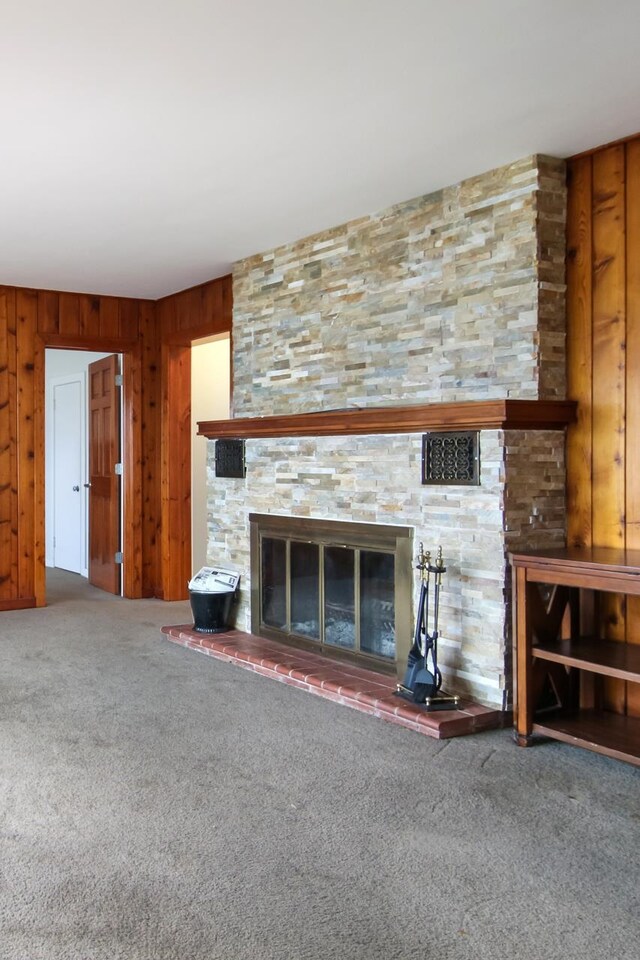 12225 SW Torch Lake Dr SW, Rapid City, MI 49676 - unfurnished living room with a fireplace, carpet floors, and wooden walls