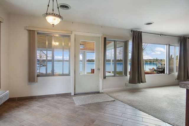 12225 SW Torch Lake Dr SW, Rapid City, MI 49676 - doorway with a water view and baseboards