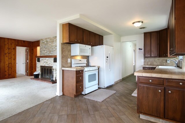 12225 SW Torch Lake Dr SW, Rapid City, MI 49676 - kitchen featuring white appliances, a sink, tasteful backsplash, and tile countertops