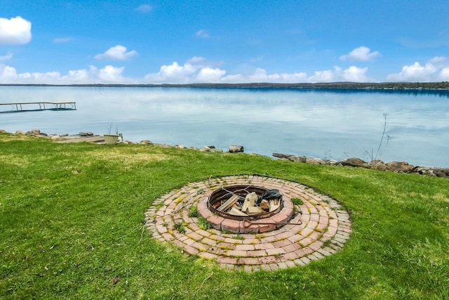 12225 SW Torch Lake Dr SW, Rapid City, MI 49676 - view of grassy yard featuring an outdoor fire pit and a water view