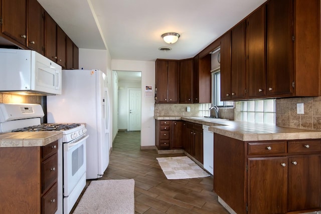 12225 SW Torch Lake Dr SW, Rapid City, MI 49676 - kitchen with white appliances, dark wood-style floors, backsplash, and light countertops