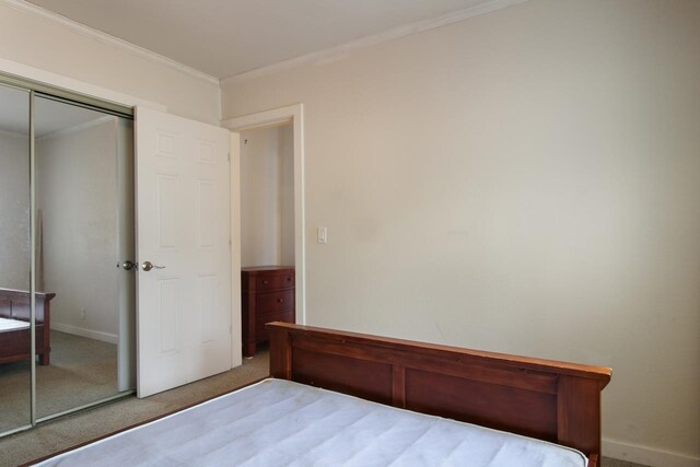 12225 SW Torch Lake Dr SW, Rapid City, MI 49676 - carpeted bedroom featuring ornamental molding, a closet, and baseboards