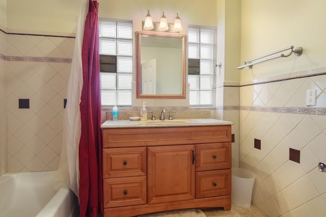 12225 SW Torch Lake Dr SW, Rapid City, MI 49676 - full bath with tile walls, healthy amount of natural light, vanity, shower / tub combo, and a wainscoted wall