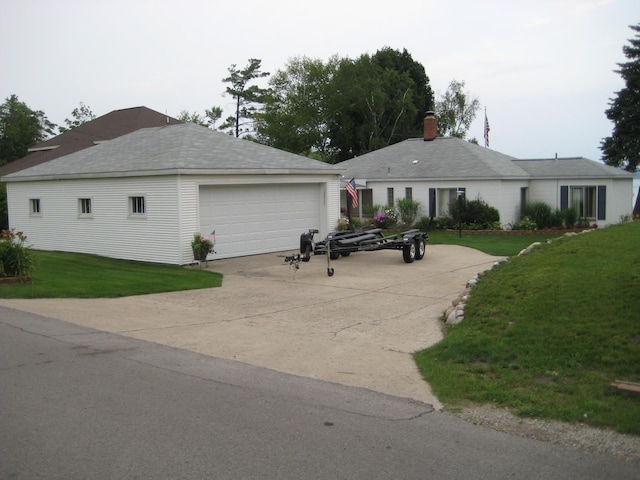 12225 SW Torch Lake Dr SW, Rapid City, MI 49676 - single story home featuring an outdoor structure, a garage, a front yard, and a chimney