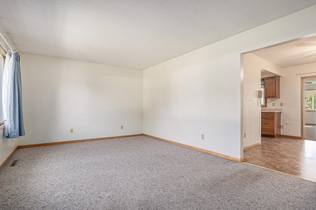 unfurnished room with light colored carpet, healthy amount of natural light, and baseboards