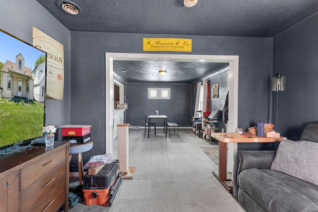 living area with a textured wall, carpet floors, and a textured ceiling