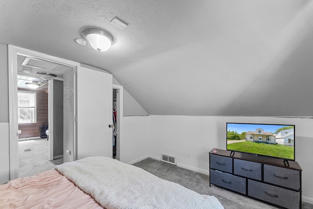 bedroom with carpet floors, baseboards, a textured ceiling, vaulted ceiling, and attic access