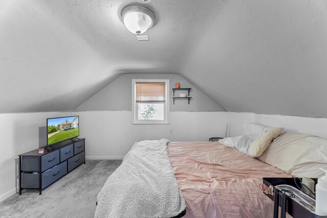 bedroom with a textured ceiling, baseboards, carpet, and lofted ceiling