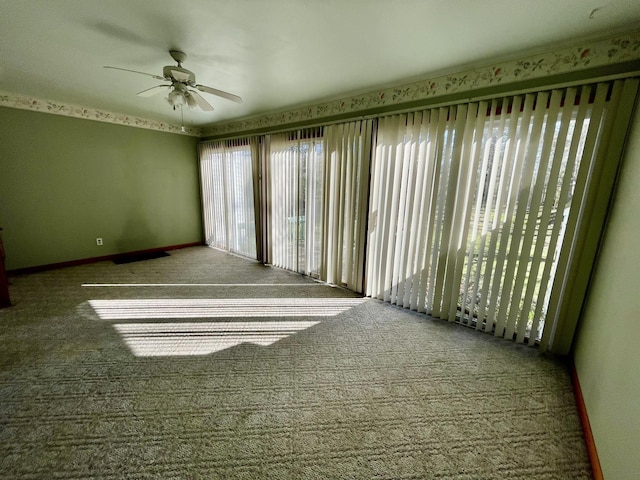 unfurnished room with carpet floors, a ceiling fan, and baseboards