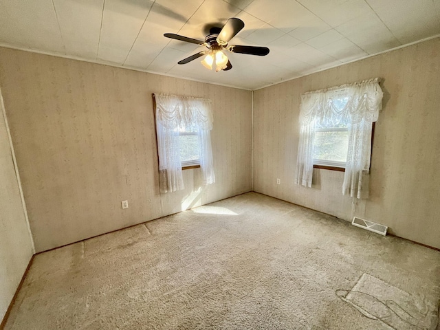 carpeted empty room with healthy amount of natural light and ceiling fan