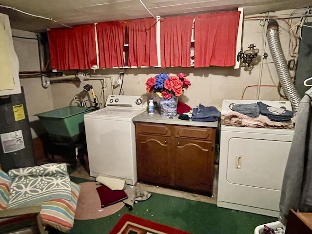 clothes washing area featuring washer / dryer, concrete block wall, cabinet space, and water heater