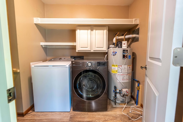 3484 Lakeshore Dr, Monroe, MI 48162 - washroom featuring water heater, cabinet space, washing machine and clothes dryer, light wood-style floors, and baseboards