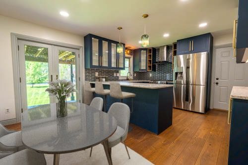 3484 Lakeshore Dr, Monroe, MI 48162 - kitchen with stainless steel fridge with ice dispenser, wall chimney range hood, wood finished floors, glass insert cabinets, and blue cabinets