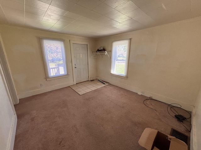 entrance foyer with ornamental molding, light carpet, and baseboards