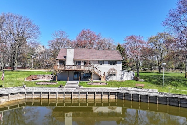 8439 Shoshoni Pass, Pigeon, MI 48755 - rear view of house with stairs, a chimney, a deck with water view, and a lawn