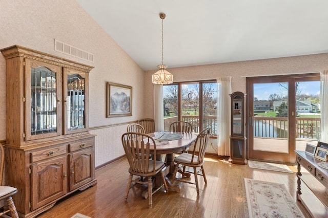 8439 Shoshoni Pass, Pigeon, MI 48755 - dining room featuring light wood-type flooring, wainscoting, and high vaulted ceiling