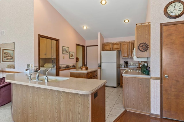 8439 Shoshoni Pass, Pigeon, MI 48755 - kitchen with freestanding refrigerator, a kitchen island with sink, light countertops, separate washer and dryer, and light tile patterned floors