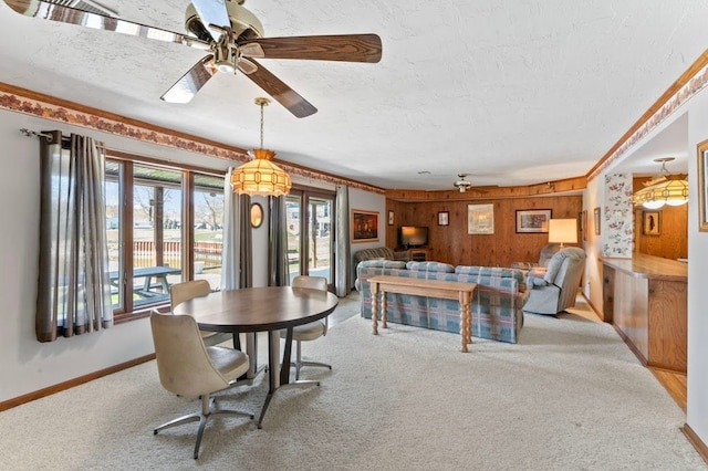 8439 Shoshoni Pass, Pigeon, MI 48755 - carpeted dining area with a textured ceiling, baseboards, ceiling fan, and wood walls