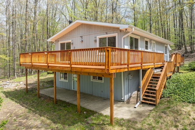 10302 Mountain View Trl, Canadian Lakes, MI 49346 - back of house with a patio, a deck, stairs, a carport, and a forest view