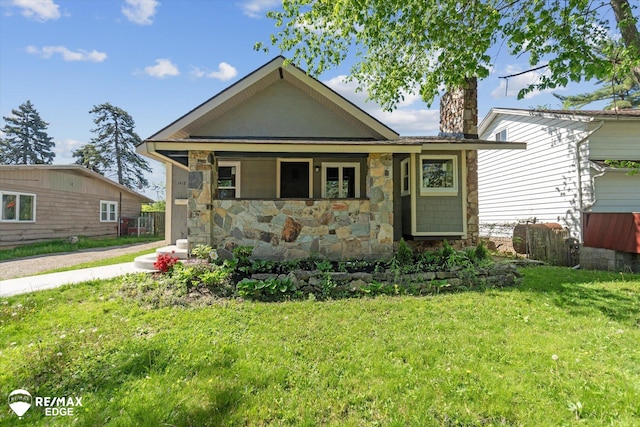 1418 Sunnyside Ave, Flint, MI 48503 - view of front of property featuring stone siding, a front lawn, and a chimney