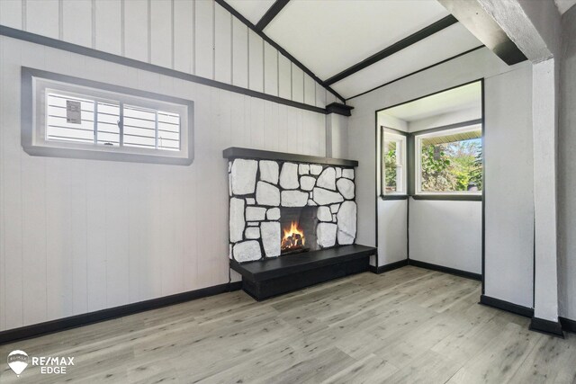 1418 Sunnyside Ave, Flint, MI 48503 - unfurnished living room featuring wood finished floors, vaulted ceiling, a stone fireplace, and baseboards