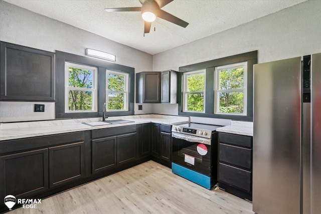 1418 Sunnyside Ave, Flint, MI 48503 - kitchen with stainless steel appliances, a sink, light wood-type flooring, a textured ceiling, and a ceiling fan