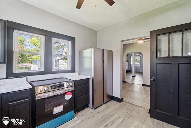 1418 Sunnyside Ave, Flint, MI 48503 - kitchen featuring stainless steel appliances, ceiling fan, arched walkways, light wood-type flooring, and a textured ceiling
