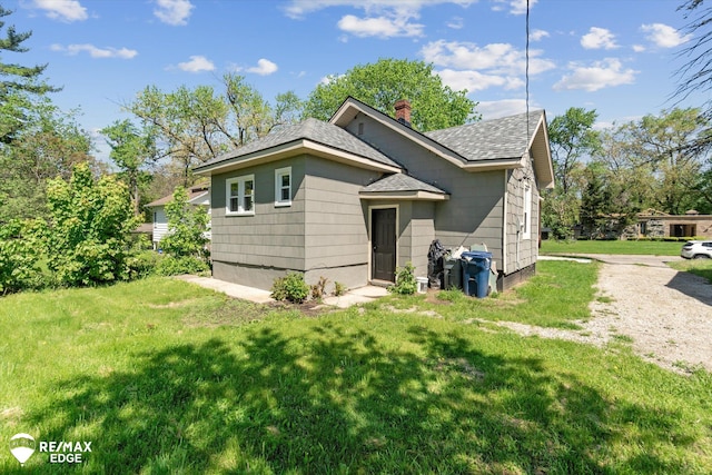 1418 Sunnyside Ave, Flint, MI 48503 - view of front of home with roof with shingles, a front yard, and a chimney