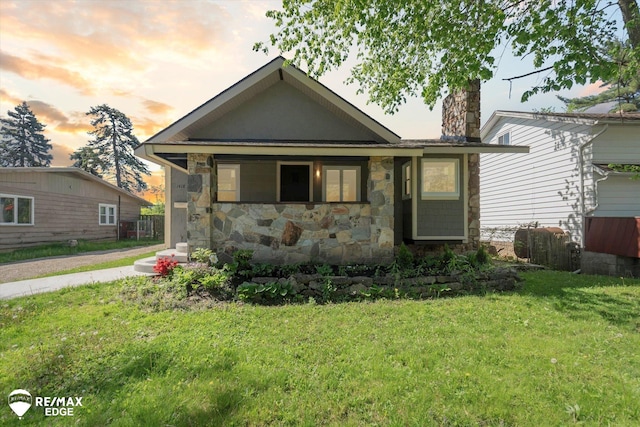 1418 Sunnyside Ave, Flint, MI 48503 - view of front of property with stone siding, a yard, and a chimney