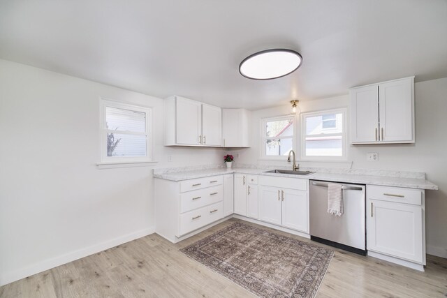923 Maple St, Ludington, MI 49431 - kitchen with dishwasher, a sink, light wood-style flooring, light countertops, and white cabinets