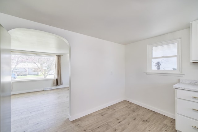 923 Maple St, Ludington, MI 49431 - unfurnished room featuring light wood finished floors, baseboards, and arched walkways