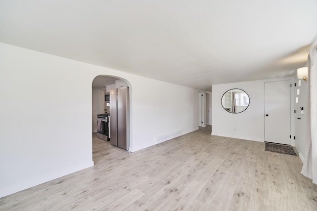 923 Maple St, Ludington, MI 49431 - foyer featuring light wood-style floors, baseboards, and arched walkways