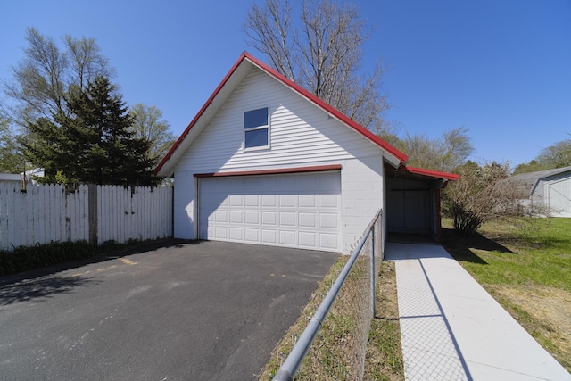 923 Maple St, Ludington, MI 49431 - view of front facade with fence, an outdoor structure, and a garage