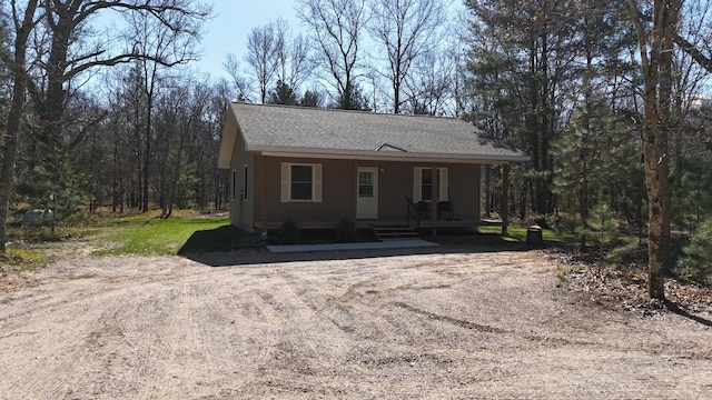 2073 Gunn Rd, Manistee, MI 49660 - view of front facade with covered porch and a shingled roof