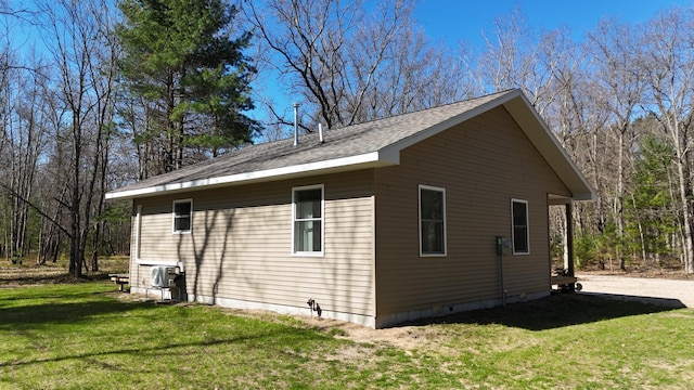 2073 Gunn Rd, Manistee, MI 49660 - view of side of home with a lawn and a shingled roof