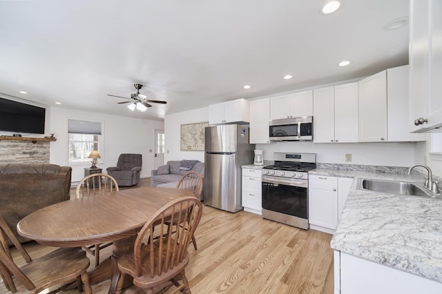 2073 Gunn Rd, Manistee, MI 49660 - kitchen featuring appliances with stainless steel finishes, a sink, a ceiling fan, open floor plan, and white cabinets