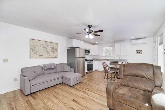 2073 Gunn Rd, Manistee, MI 49660 - living area with a wall mounted air conditioner, light wood-style flooring, a ceiling fan, recessed lighting, and baseboards