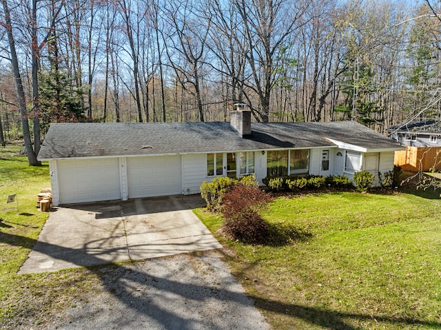 view of front of property with a chimney, concrete driveway, a garage, and a front yard