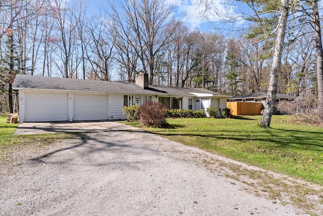 view of front of property with gravel driveway, a garage, and a chimney