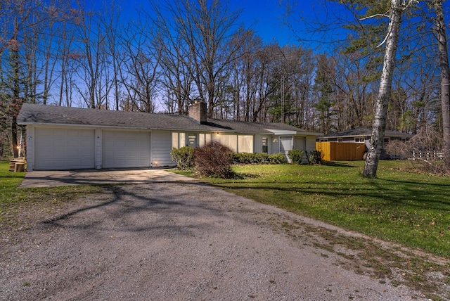 view of front of house with driveway, a garage, and a chimney