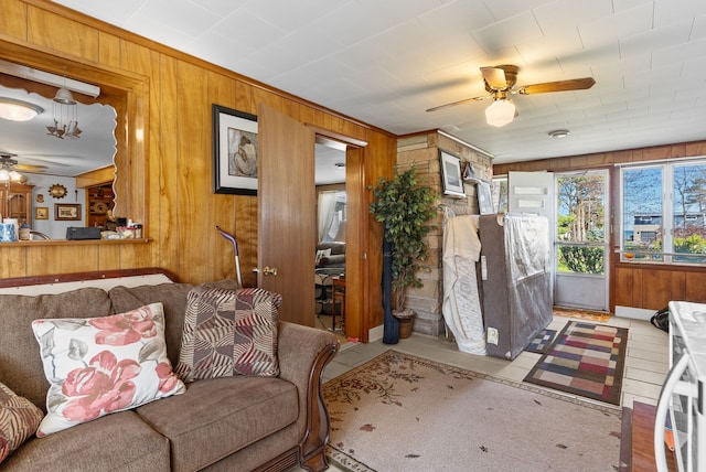 living room featuring ceiling fan and wooden walls