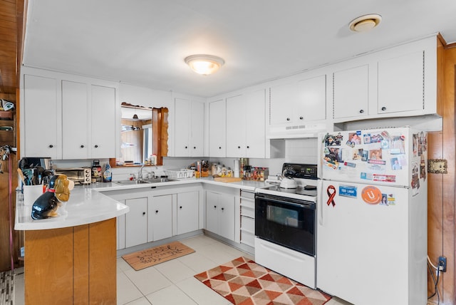 kitchen featuring white appliances, under cabinet range hood, a sink, a peninsula, and white cabinets