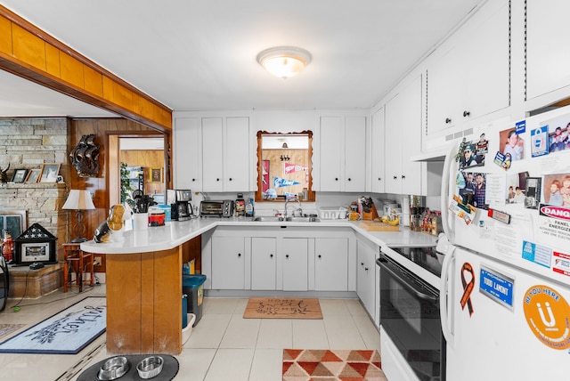 kitchen featuring freestanding refrigerator, range with electric cooktop, a sink, a peninsula, and light countertops