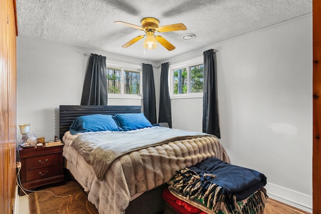 bedroom featuring a textured ceiling, a ceiling fan, and baseboards
