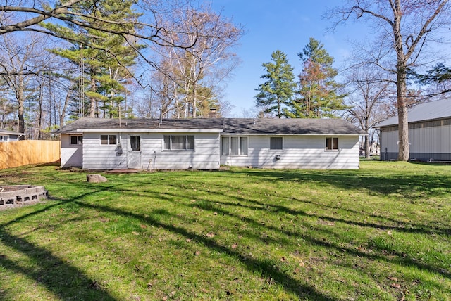 rear view of house with a chimney and an outdoor fire pit