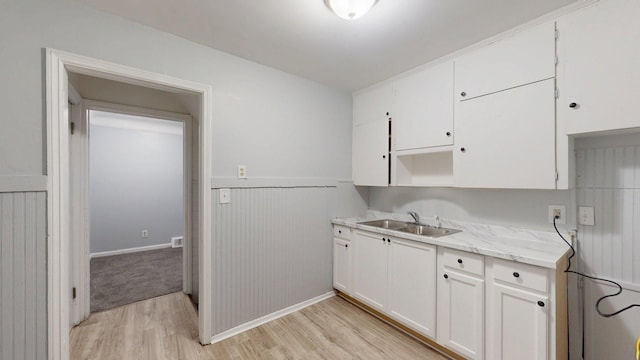 20026 Joann St, Detroit, MI 48205 - kitchen with a sink, light wood finished floors, wainscoting, white cabinets, and baseboards