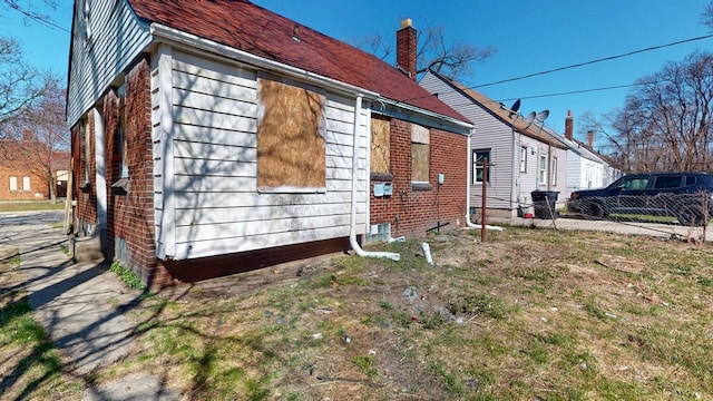 20026 Joann St, Detroit, MI 48205 - view of side of home with fence, brick siding, and a chimney