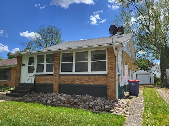 1116 Atlantic St NW, Grand Rapids, MI 49504 - view of side of property featuring entry steps, brick siding, driveway, a detached garage, and an outdoor structure